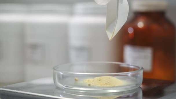 Close-up de utensílios de laboratório de química de vidro com algum pó químico branco com pequenas garrafas borradas no fundo. Imagens de stock. Experiência química — Vídeo de Stock