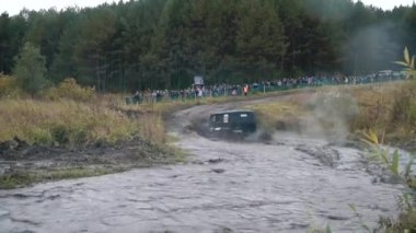 Bir off-road yarış katılan ve büyük su birikintileri geçiş Rus SUV'lar yakın çekim. Küçük. Rus yollar