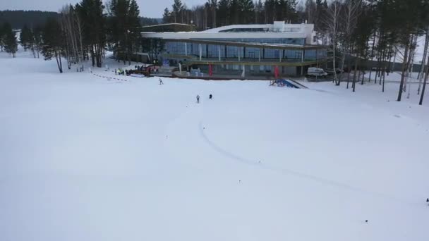 Vista aérea de dos atletas que participan en una competición de esquí y que descienden a la meta. Filmación. Deportes y competiciones — Vídeos de Stock