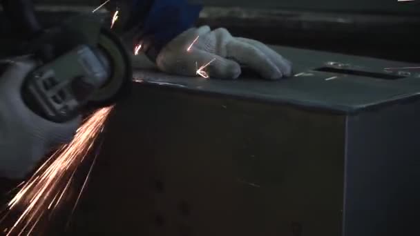 Primer plano de las manos de los trabajadores masculinos en guantes de trabajo grises y uniforme azul oscuro moliendo una esquina de la caja de acero grande. Una trampa. Concepto de construcción — Vídeos de Stock