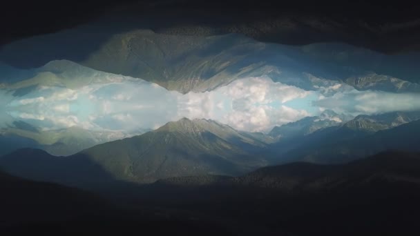 Εναέρια άποψη από τα μεγάλα βουνά που καλύπτονται από το πράσινο γρασίδι και δέντρα ενάντια μπλε και θολό ουρανό με φαινόμενο αντικατοπτρισμού αφηρημένη. Βολή. Αφηρημένη αντανάκλαση — Αρχείο Βίντεο