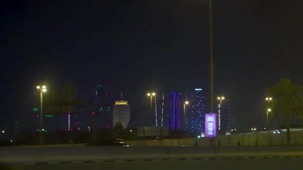 Dubái, Emiratos Árabes Unidos - febrero de 2018: Escena callejera de Dubái con senderos para semáforos y nueva vista de la ciudad por la noche. Acciones. Vista desde el coche por la noche Dubai — Vídeos de Stock