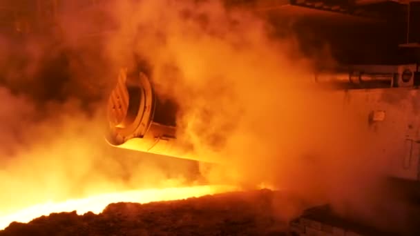 Métal fondu coulant dans la goulotte à l'usine entourée de clubs de vapeur. Images d'archives. Industrie lourde et usine métallurgique de production d'acier . — Video