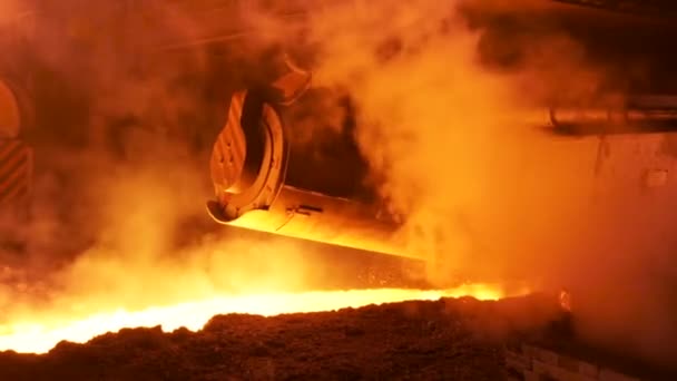 Logam cair mengalir dalam saluran di pabrik dikelilingi oleh klub uap. Rekaman saham. Industri berat dan metalurgi produksi baja . — Stok Video