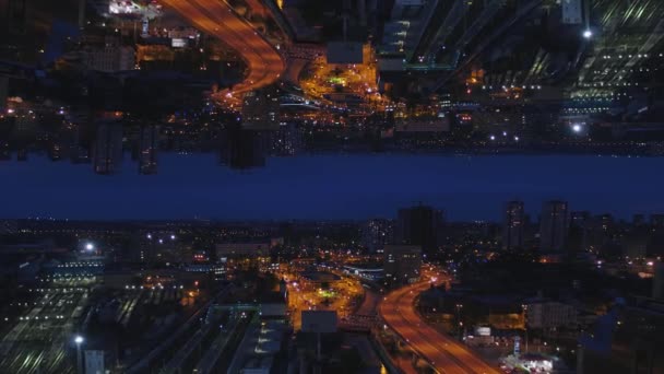 Vista aérea nocturna de una gran ciudad y hermosas luces, concepto de vida nocturna, efecto espejo horizonte. Medios. Paisaje urbano nocturno con carreteras iluminadas y coches en movimiento, tema de inicio . — Vídeo de stock