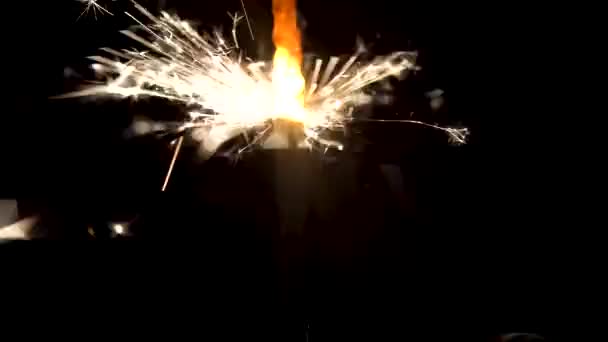 Bengalen vuur met mooie sparkles geïsoleerd op zwarte achtergrond. Media. Brandende sparkler in het donker, Merry Christmas-concept. — Stockvideo