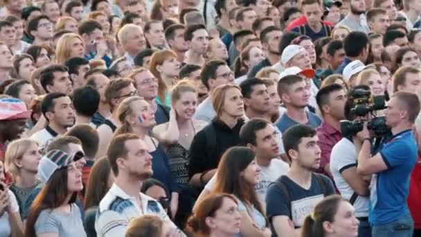 Multitud de personas viendo la transmisión del partido de fútbol en una plaza. Imágenes de archivo. Fútbol fans — Vídeo de stock