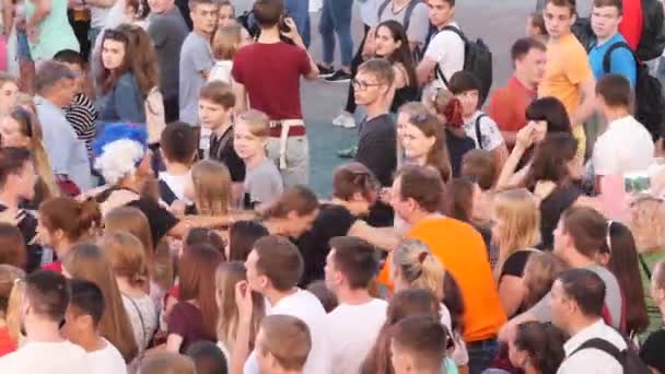 Crowd af mennesker, der danser på en firkant under udsendelsen af fodboldkamp. Aktieoptagelser. Fodboldfans – Stock-video