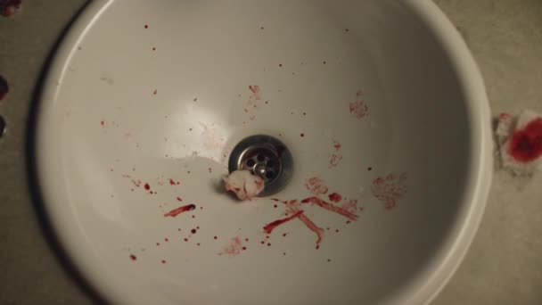 Közeli kép a fehér mosogató véres vatta letöröl és vér foltok. Stock footage. Valaki dobott őket egy mosogató — Stock videók