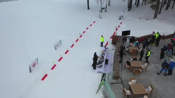 Flygfoto över människor på en skidstuga som förbereder för en ski-tävling. Footage. Sport och tävlingar — Stockvideo