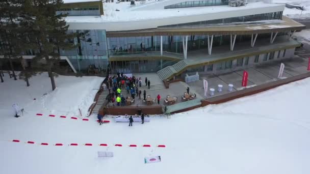 Luchtfoto van ski-lodge, sportsmens, jury en organisatoren voorbereiden op een ski-competitie. Beeldmateriaal. Sport en competities — Stockvideo