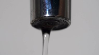 Aşırı yakın aşağı düşen musluk ve su damla. Medya. Gümüş sızdıran musluk ile düşen su damlaları.