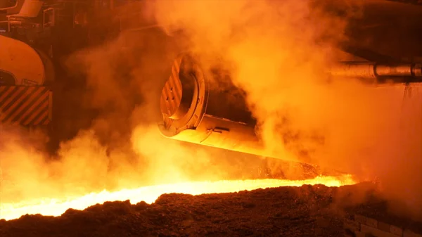 Metal fundido fluyendo en paracaídas en la fábrica rodeado de clubes de vapor. Imágenes de archivo. Industria pesada y planta metalúrgica de producción de acero . — Foto de Stock