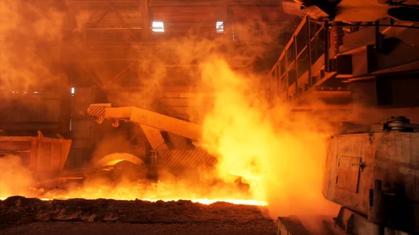 Hot steel being poured to the chute at the steel plant, heavy industry concept. Stock footage. Molten steel production in electric furnaces.