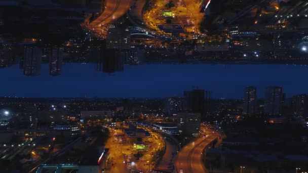 Noční Panorama a město s mnoha světlými světly a auty, které se pohybují po silnicích, efekt zrcadlového obzoru. Media. Úžasná noční krajina s budovami, Mrakodrapy a osvětlenými cestami, zahajovací téma. — Stock video