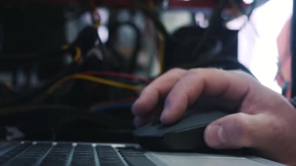 Close-up van systeembeheerder hand werken op laptop en te klikken computer muis in datacenter. Stock footage. Beheerders werken — Stockvideo