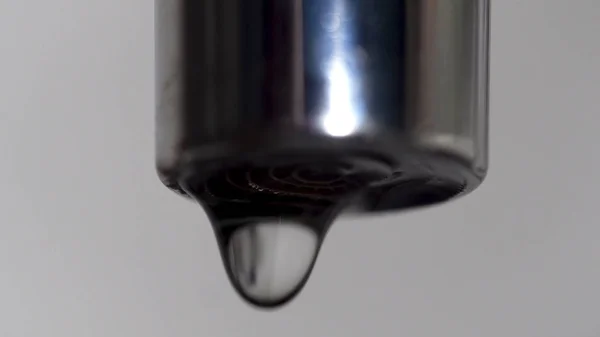 Estremo primo piano del rubinetto e gocce d'acqua cadere. I media. Perdita di rubinetto d'argento con gocce d'acqua cadenti . — Foto Stock