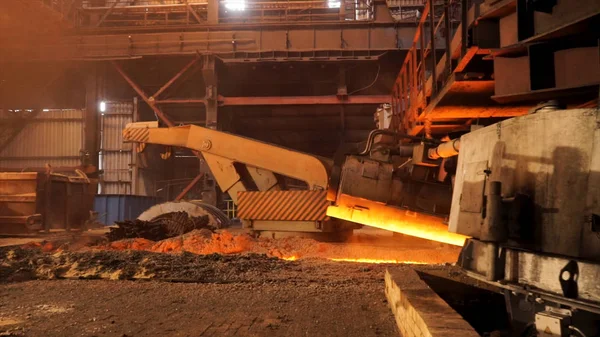 Hot metal production at the factory, metallurgy concept. Stock footage. Molten steel flowing in metallurgical chute, heavy industry.