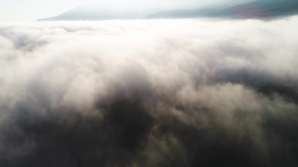 Vue aérienne des nuages et du paysage sous eux. Fusillade. Vue de dessus des nuages sous le ciel. Sous les nuages d'un vol d'oiseaux, le soleil brille sur les nuages — Video