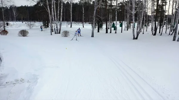 Ski race on track in winter. Footage. Top view of competing professional skiers in colorful costumes riding on track. Winter cross-country skiing competitions — Stock Photo, Image