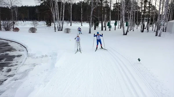 Gara di sci in pista in inverno. Un filmato. Vista dall'alto di sciatori professionisti in costume colorato in pista. Concorsi invernali di sci di fondo — Foto Stock