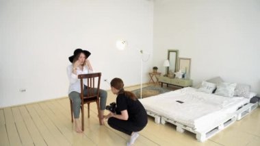 Çekim öncesi kadın fotoğrafçı ve model. Medya. Fotoğrafçı stüdyoda resim çekmeden önce modelin ayrıntılarını düzeltir