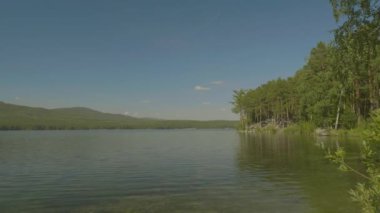Ormanda güzel dağ gölü. Bir göl ile güzel manzara. Aynaya su yüzeyine mavi gökyüzü yansıtır.