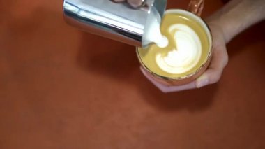 Adam coffe'dan yararlanır. Madde. Profesyonel barista coffe krem ile kalp çizer. Sütle çizim kahve sanatı