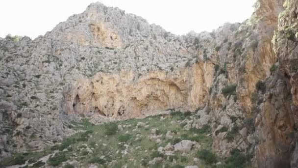 Vista inferior del acantilado sobre el fondo del cielo. Art. Rodeado de montañas rocosas con vegetación a pie y arbustos escasos en el fondo del cielo — Vídeo de stock