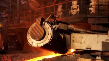 Metalurji fabrikasında yüksek sıcaklığa eriyen erimiş çelik. Stok görüntüleri. Elektrik fırınında yavaşça kameraya doğru hareket eden çelik üretimi.