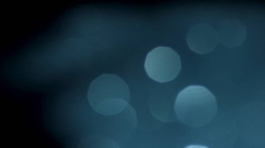 Parlayan mavi ışık fişekleri yavaşça hareket eden bulanık arka plan. Stok görüntüleri. Yuvarlak Soyut Beyaz rakamlar turkuaz parlayan ile yüzen.