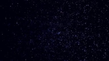 Uzayda siyah arka planda birçok mavi, mor, dönen parçacıklar. Animasyon. Dönen küçük dairelerin renkli bulutu, kesintisiz döngü.