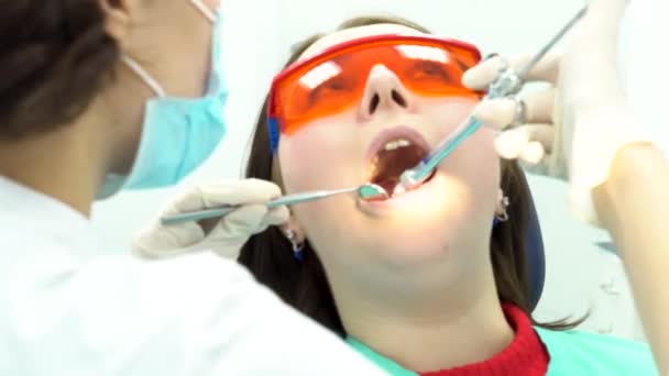 Дантист держит шприц и обезболивает пациента. СМИ. Пациентка с открытым ртом получает инъекцию в кабинете стоматолога, концепция медицины . — стоковое видео