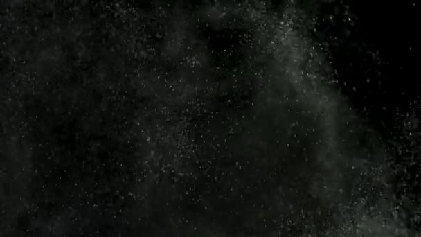 Escombros de polvo blanco que explotan en el fondo negro, rotura de aerosol de polvo de movimiento en textura oscura. Imágenes de archivo. Hermosas partículas pequeñas salpicando y cayendo . — Vídeos de Stock