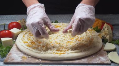 Şeflerin, tahta bir tahtaya dört peynirli pizzaya mavi peynir eklemesi yakın çekim. Çerçeve. Lezzetli pizza hazırlama