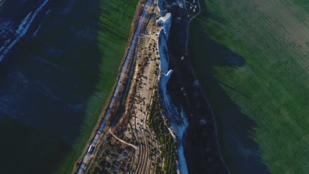 Bovenaanzicht van de luchtwegen op een snelweg in de buurt van de adembenemende witte klif tussen twee groene valleien in een zonnige dag. Beelden. Prachtige zomer landschap — Stockvideo