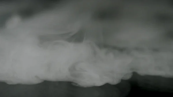 黒い背景に孤立した白い霧、スモーキー効果。ストック映像。黒い背景にぼやけた煙雲のオーバーレイ. — ストック写真