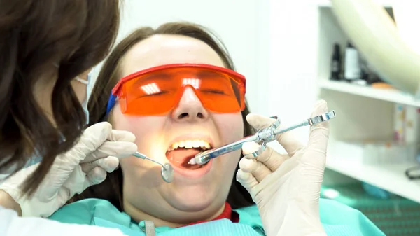 Close-up portret van een meisje bang van naalden en spuiten bij tandartsbezoek. Media. Vrouwelijke tandarts maken van verdovings injectie naar bang vrouwelijke patiënt. — Stockfoto