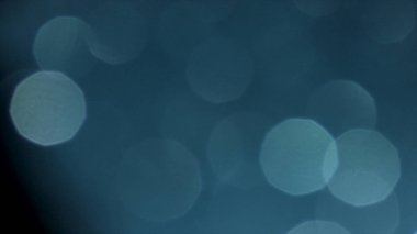 Parlayan mavi ışık fişekleri yavaşça hareket eden bulanık arka plan. Stok görüntüleri. Yuvarlak Soyut Beyaz rakamlar turkuaz parlayan ile yüzen.