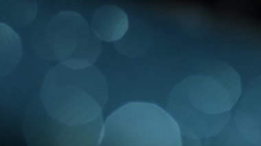 Mavi ve turkuaz bokeh ve fişekleri ile soyut arka plan. Stok görüntüleri. Kaotik olarak yüzen beyaz yarı saydam daireler.