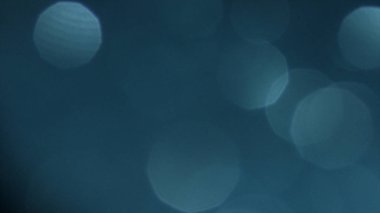 Mavi ve turkuaz bokeh ve fişekleri ile soyut arka plan. Stok görüntüleri. Kaotik olarak yüzen beyaz yarı saydam daireler.