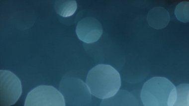 Bokeh ışıkları her tarafta hareket ile defocused mavi arka plan. Stok görüntüleri. Gölgeli yeşil mavi renkte doğa parlayan güneş ışığı parlamaları ve bokeh ile bulanıkgökyüzü arka plan.