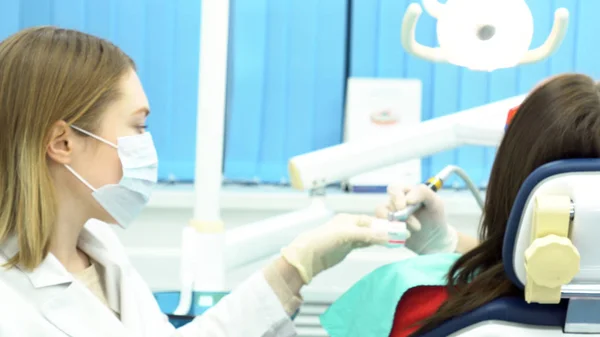 Limpieza dental profesional de dientes de paciente femeninos en clínica dental, concepto de medicina. Medios. Mujeres dentistas haciendo el procedimiento de limpieza y pulido de dientes en el consultorio del dentista . — Foto de Stock