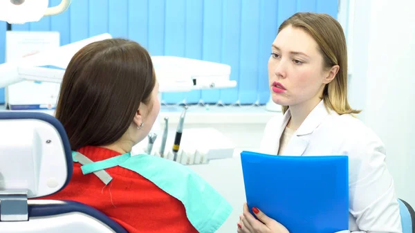 Vrouwelijke jonge tandarts praten met vrouw patiënt op Dental Clinic kantoor, geneeskunde, tandheelkunde en gezondheidszorg concept. Media. Arts en patiënt bespreken tanden behandeling. — Stockfoto