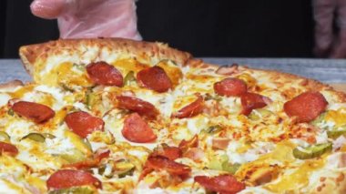Şeflerin silikon eldivenlerle ellerinin yakın çekimi, tasarruf lu ve peynirli dairelerle lezzetli taze Napoli pizzası alıyor. Çerçeve. İtalyan yemekleri