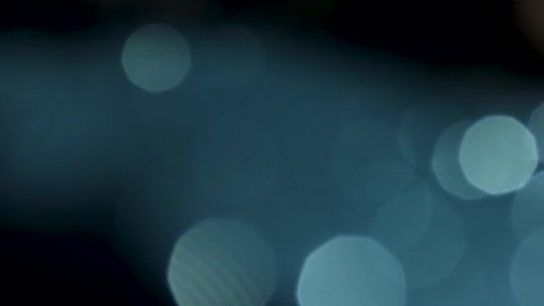 Dsigital lens flares moving slowly with dim light on black background. Stock footage. Beautiful white shining circles floating chaotically. — Stock Video