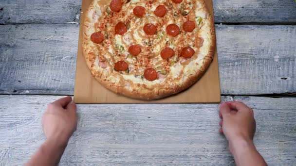 Νόστιμη πίτσα σε ξύλινο δίσκο σε λευκό φόντο τραπεζιού. Πλαίσιο. Ο άνθρωπος μετακινεί φρεσκοψημένη πίτσα με πεπερόνι σε ξύλινο δίσκο — Αρχείο Βίντεο