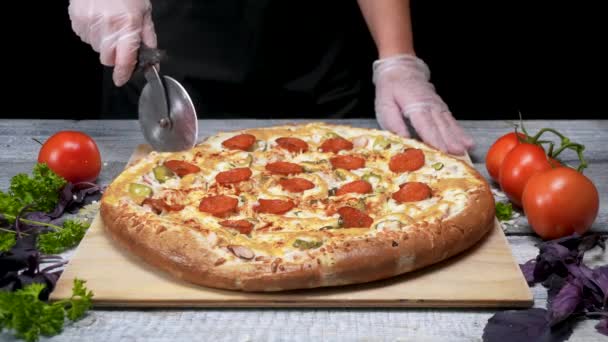 Cook cuts pizza with roller knife. Frame. Chef gloves cut roller knife freshly baked pizza. Cutting delicious pizza before serving — Stock Video