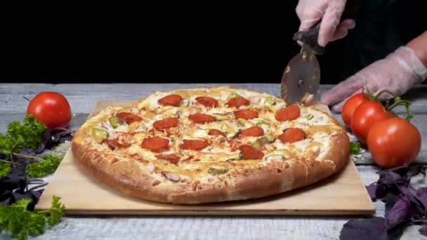 Cucinare taglia la pizza con il coltello a rullo. Cornice. Guanti da chef tagliano la pizza appena sfornata. Tagliare deliziosa pizza prima di servire — Video Stock