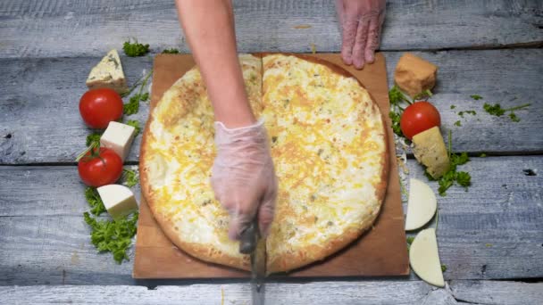 Νόστιμη πίτσα κομμένη με μαχαίρι. Πλαίσιο. Ο σεφ κόβει την πίτσα σε ξύλινο δίσκο με επαγγελματικό μαχαίρι πριν από το σερβίρισμα. Πιτσαρία και νόστιμη τροφή της πίτσας — Αρχείο Βίντεο